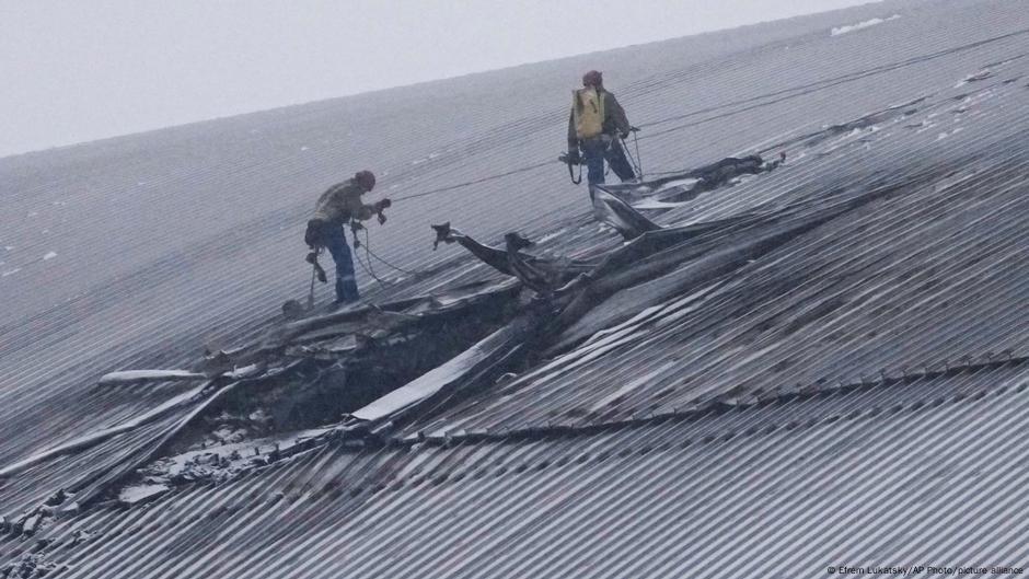 Zwei Arbeiter befinden sich auf der beschädigten Schutzhülle des ehemaligen Kernkraftwerks Tschernobyl