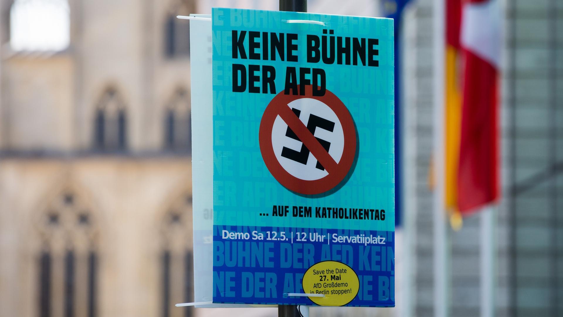 Ein Plakat mit der Aufschrift "Keine Bühne der AfD auf dem Katholikentag" hängt vor dem historischen Rathaus in Münster