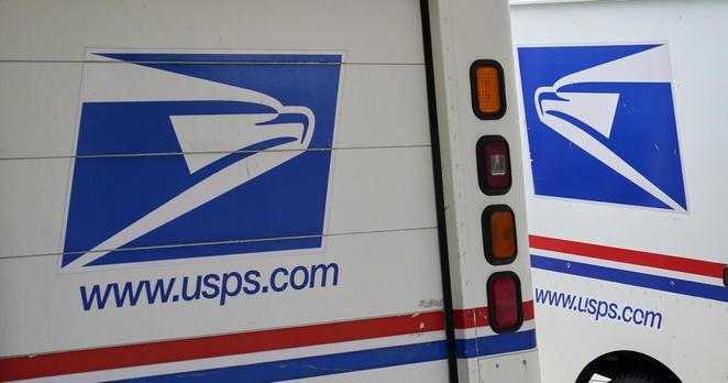 FILE - U.S. Postal Service delivery vehicles are parked outside a post office in Boys Town, Neb., Aug. 18, 2020. (AP Photo/Nati Harnik, File)