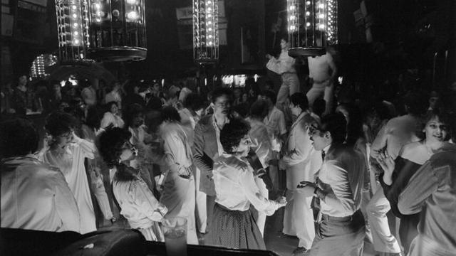 Hommes et femmes sur la piste de danse d'une discothèque.