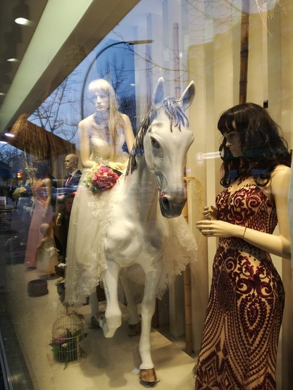 Schaufenster. Weibliche Schaufensterpuppe in Hochzeitskleid auf Pferd. 