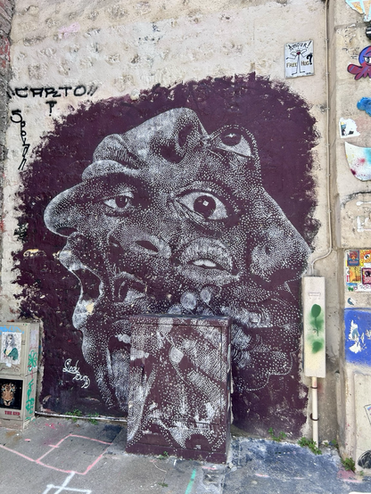 Graffiti aus weißen Punkten auf schwarzem Hintergrund mit einem kubistischen Gesicht