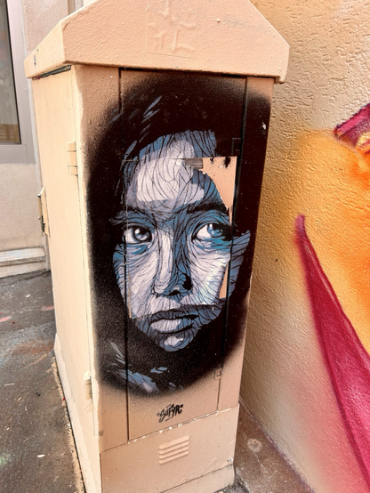 Graffiti auf einem Stromkasten, Gesicht eines Mädchens