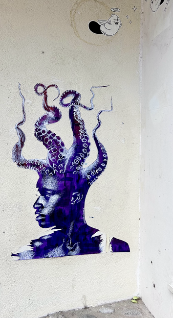 Graffiti mit einem Gesicht aus dessen Kopf anstelle der Haare Tentakel wachsen