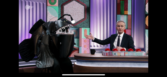 Der zmr-Nachbau eines Anglerfisches sitzt neben Jan am Schreibtisch.